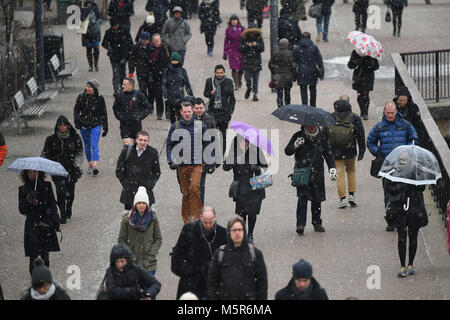 Commuters walking in the snow in London as some parts of the UK are set to feel colder than the Arctic Circle as freezing temperatures continue into the week ahead. Stock Photo