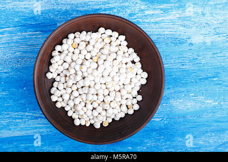Vegetarian nutritious food, chickpeas in a clay plate on a wooden background, top view, horizontal photo Stock Photo