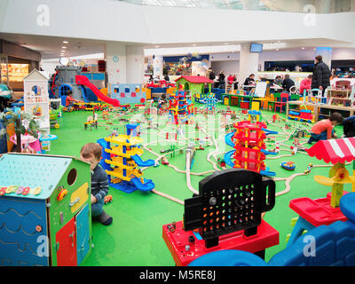 Kids playing in game zone in shopping mall. Play zone in modern shopping mall, kids zone. Copy space Stock Photo