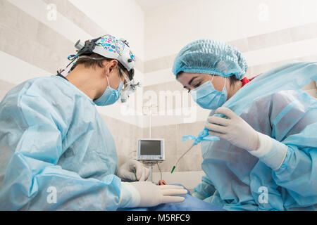 Professional dental checking and treatment. The dentist's office. Doctor and assistant for the work process. the surgeon the dentist is performing sur Stock Photo