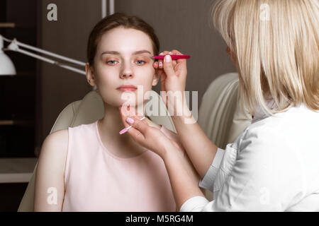 Permanent microblasting tattooing freckles to a woman in a beauty salon Stock Photo