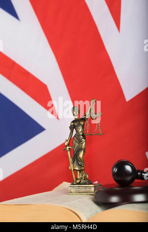 Statue  Themis on a flag of Great Britain. Judge's gavel in the background Stock Photo