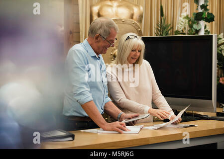 Event Organiser Businesspeople are discussing paperwork and are using a digital tablet. Stock Photo