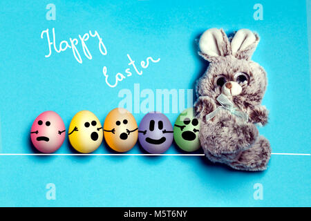 Easter bunny with painted eggs with drawing muzzle, go in a row with a train, Easter card Stock Photo