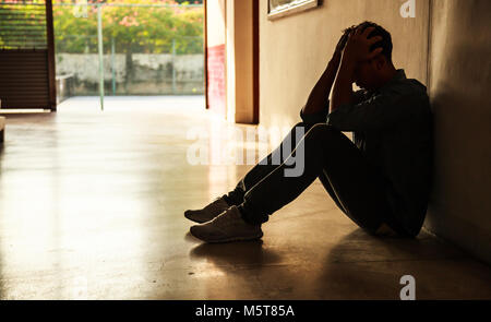Emotional moment: man sitting holding head in hands, stressed sad young male having mental problems, feeling bad, depressed, disappointed, hopeless. D Stock Photo