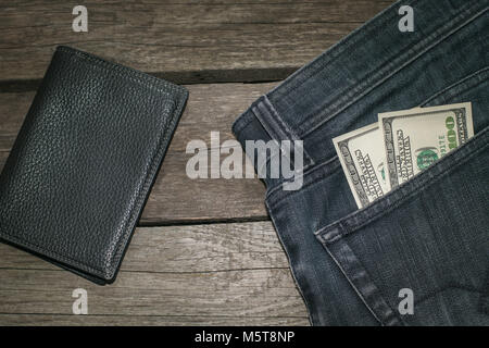 Black wallet and American dollars in the pocket of the Jeans. Top view. Stock Photo