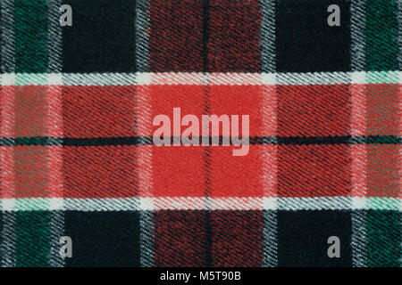 Soft and warm checkered wool blanket. Green and red plaid texture, macro shot. Wool plaid pattern. Textured surface of checkered cloth. Stock Photo