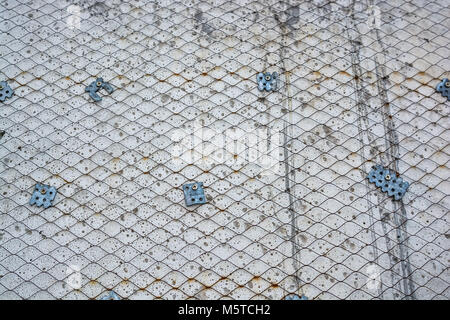 Plaster wall with metal grid mesh on it Stock Photo