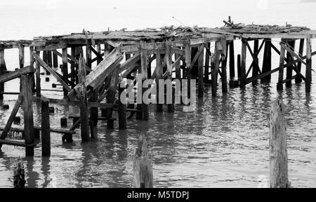 Dilapidated boat dock falling apart on the water Stock Photo