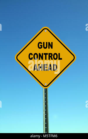 Gun control ahead road sign against blue sky Stock Photo