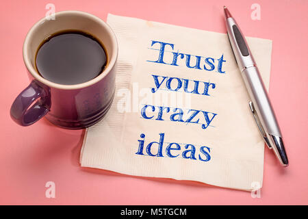Trust your crazy ideas reminder - handwriting on a naokin with a cup of coffee Stock Photo