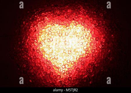 Shining heart of red decoration stones against a dark background Stock Photo