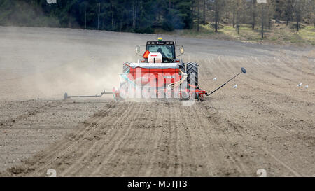 SALO, FINLAND - APRIL 18, 2015: Unidentified farmer cultivates field with Valmet 8550 tractor and seeder. Finnish farmers are able to hit the fields i Stock Photo