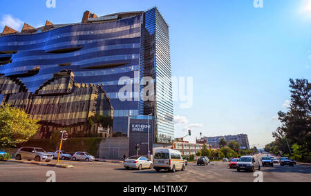 Traffic intersection with cars and modern buildings in background Stock Photo