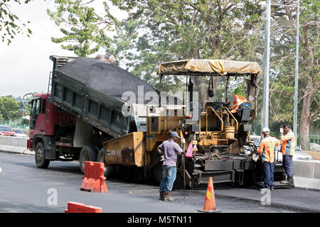 PENANG, MALAYSIA, NOV 10 2017, The asphalt machine puts a new surface - layer on the road. A repaving construction of road. Stock Photo