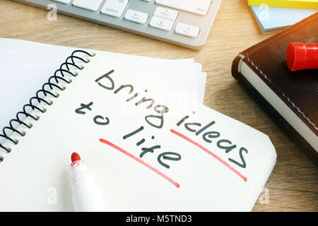 Bring ideas to life written in a note. Stock Photo