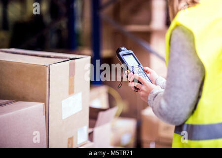 Warehouse woman worker with barcode scanner. Stock Photo