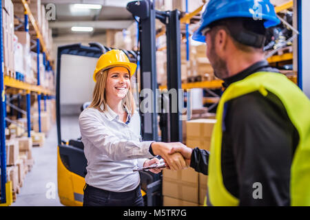 Young warehouse workers working together. Stock Photo