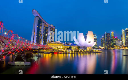 View at the Marina Bay district in Singapore at night with the iconic landmarks of The Helix Bridge and The Marina Bay Sands. Stock Photo