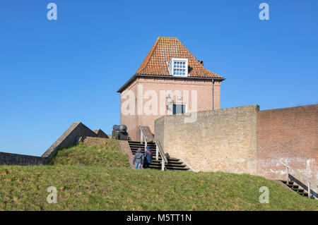 Old, medieval fortifications and buildings on the embankment in Heusden, Holland. Bricks wall and canons. Stock Photo