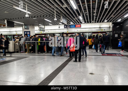 HONG KONG - February 21, 2018: Crowded people walking access to the subway in MTR underground station in Hong Kong. MTR is the most popular transport  Stock Photo