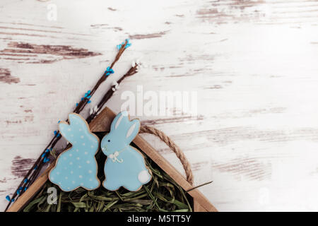 Easter gingerbread cookies on wooden table. Beautiful glazed rabbits. Greeting card. View from above.Copy space. Stock Photo