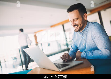 Young handsome architect working on laptop in office Stock Photo