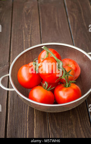 ripe tomatoes on a wooden table Stock Photo