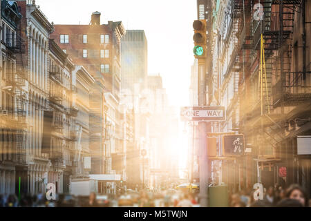 Sunlight shines on people walking the streets of SoHo in New York City Stock Photo