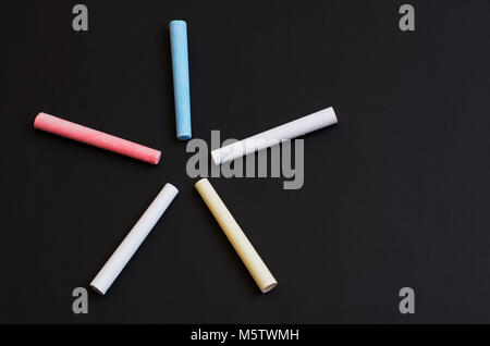 colored chalk on a black school board Stock Photo