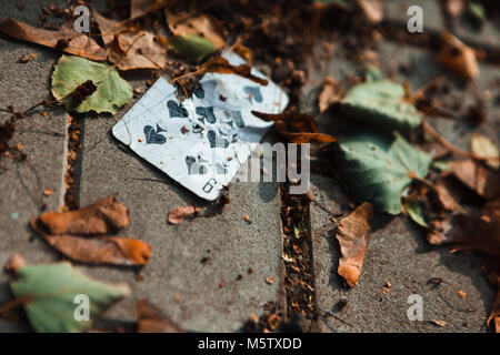 playing card on the ground with yellow leaves Stock Photo
