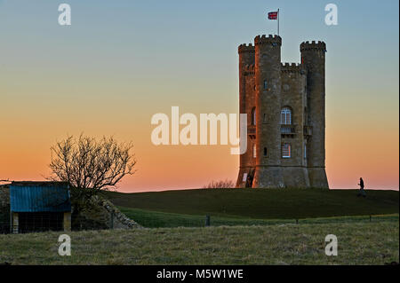 Broadway Tower on top of Fish Hill, the second highest point in the Cotswolds, is an iconic landmark, seen against a cold winter sunset sky. Stock Photo