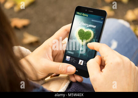 mobile design concept: woman holding a 3d generated smartphone with travel honeymoon on the screen. Graphics on screen are made up. Stock Photo