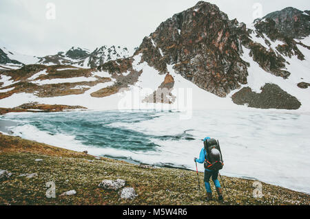 Traveling hiker man with backpack hiking in mountains Lifestyle survival concept adventure outdoor active vacations climbing sport gear wild nature Stock Photo