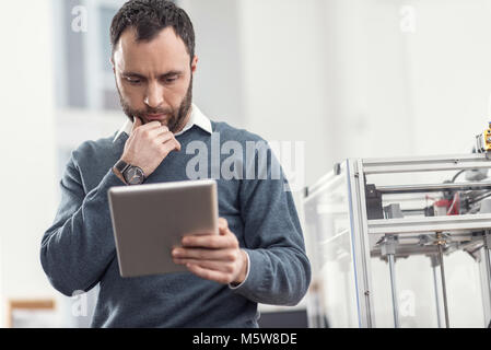 Focused young engineer reading from tablet Stock Photo