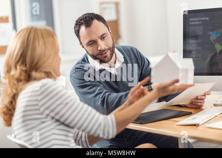 Pleasant woman sharing her opinion about 3D house model Stock Photo
