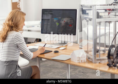 Pretty female engineer developing presentation on computer Stock Photo