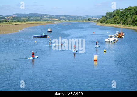 Group of people enjoy stand up paddle boarding on the river Axe near Seaton in Devon Stock Photo