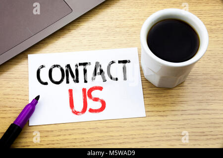 Handwriting Announcement text showing Contact Us. Business concept for Customer Support written on notebook book on wooden background in the Office wi Stock Photo
