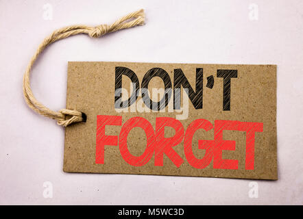 Hand writing text caption inspiration showing Do Not Forget. Business concept for Don t memory Remider written on price tag paper on white vintage bac Stock Photo