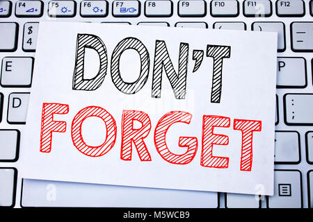 Handwritten text caption showing Do Not Forget. Business concept writing for Don t memory Remider written on sticky note paper on white keyboard backg Stock Photo