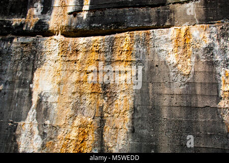 Old concrete wall with orange and white rust calcium stains running down over the top Stock Photo