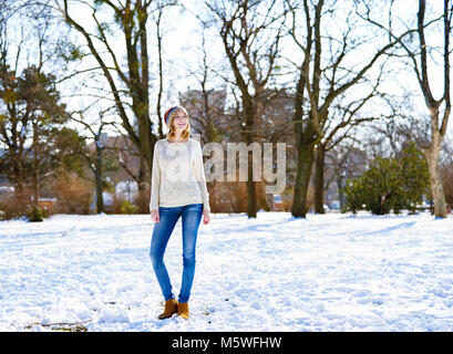 Beautiful woman in snowy city park Stock Photo