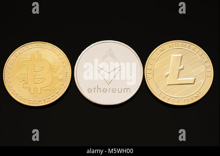 Collection of three most popular digital or cryptocurrencies. Bitcoin, Ethereum (Ether) & Litecoin on black background Stock Photo