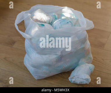 a bag full of dirty baby's   diapers standing on the floor side point view Stock Photo