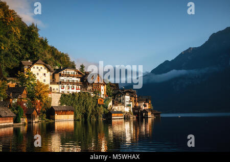 Scenic view of famous Hallstatt lakeside town reflecting in Hallstattersee lake in the Austrian Alps in morning light in autumn, Salzkammergut region, Stock Photo