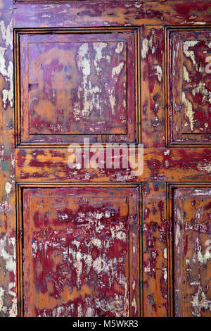 Old wooden door with paint partly stripped off Stock Photo