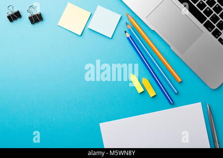 Start of Morning work office desk with computer laptop pencil Sheet paper notebook pen blue texture table Business concept background Stock Photo