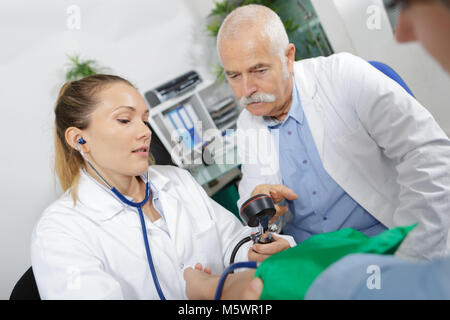 physician measuring blood pressure to make a diagnosis Stock Photo