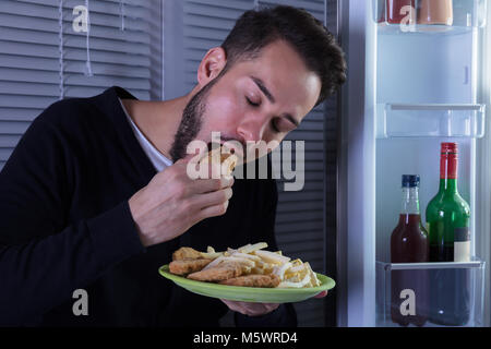 Close-up Of A Smiling Young Man Eating Fried Food In Plate Stock Photo